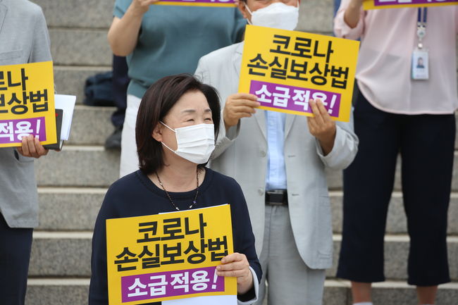 ▲ 심상정 의원이 코로나 손실보상법 소급적용을 촉구하는 피켓을 들고 서있다.