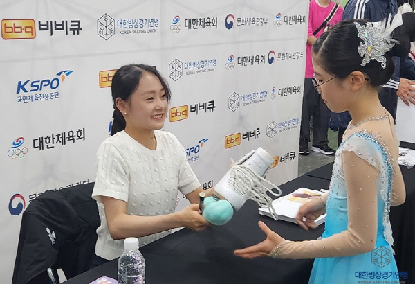피겨스케이팅 국가대표 김채연이 전국생활체육빙상대회에 참여한 팬에게 사인을 해주고 있다.