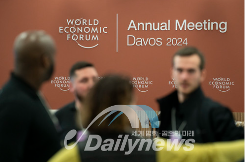 포럼 준비요원들이 행사 로고 앞에 앉아 있다. [사진=WEF]