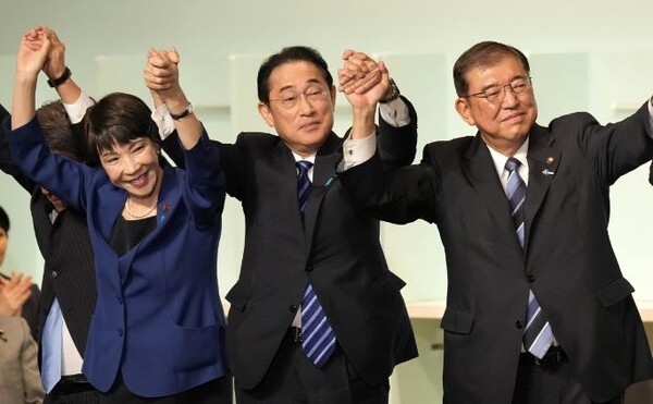 이시바 시게루 전 자민당 간사장(오른쪽)이 기시다 후미오 총리(가운데)와 손을 맞잡고 만세를 부르며 승리를 자축하고 있다. 사진=AP