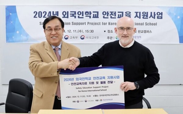 정훈 학교안전공제중앙회 이사장(왼쪽)이 11일 한국외국인학교 판교캠퍼스를 방문해 안전교육 자료와 물품을 전달한 후 기념촬영을 하고 있다. 사진=학교안전공제중앙회